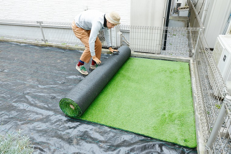 ロール状の人工芝を広げる