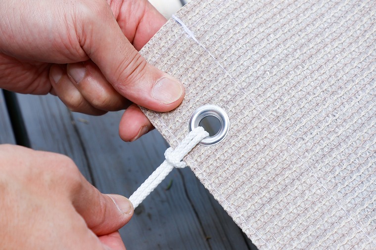 取り付けヒモをハトメに結ぶ